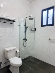 a bathroom with a toilet and a glass shower at Hotel Rincón Samaná in Las Galeras +11 photos