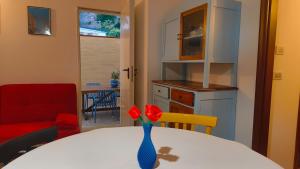 a room with a table with a vase with red flowers at CRema Beach in Palmi +21 photos