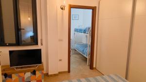 a room with a door leading to a room with a crib at CRema Beach in Palmi