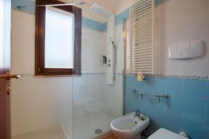 a bathroom with a shower and a toilet and a sink at Flamingo Poetto in Quartu SantʼElena +37 photos
