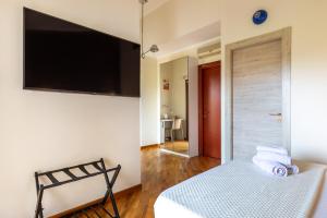 a bedroom with a bed and a television on the wall at Flamingo Poetto in Quartu SantʼElena