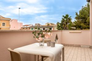 a table with a vase of flowers on a balcony at Flamingo Poetto in Quartu SantʼElena