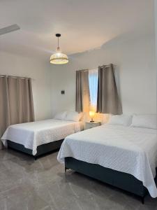 a bedroom with two beds and a chandelier at Hotel Rincón Samaná in Las Galeras