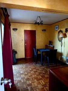 a dining room with a table and a red door at Alojamiento La Serena CQ in La Serena +8 photos