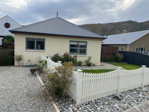 a white picket fence in front of a house at Sunny Clyde Getaway in the Heart of Clyde in Clyde