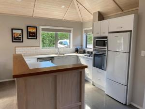 a kitchen with white cabinets and a white refrigerator at Sunny Clyde Getaway in the Heart of Clyde in Clyde