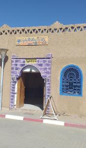 a building with a door and a sign on it at Chez zakaria guest in Erfoud +3 photos