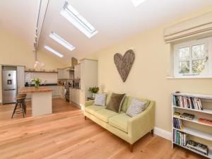 a living room with a couch and a kitchen at Beaufort Dairy in Pulborough +26 photos