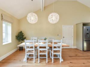 a dining room with a white table and chairs at Beaufort Dairy in Pulborough