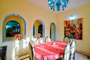 a dining room with a table and chairs and a chandelier at Baagh House villa Velsao in Cansaulim