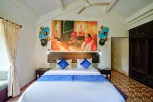 a bedroom with a bed with a painting on the wall at Baagh House villa Velsao in Cansaulim
