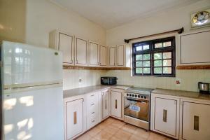 a kitchen with white cabinets and a white refrigerator at Baagh House villa Velsao in Cansaulim +49 photos