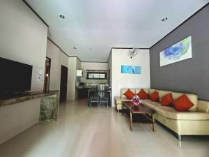 a living room with a couch and a table at Baan Suan Rim Klong Resort in Ko Lanta