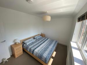 a bedroom with a bed and a dresser and a window at Lovely Central Romsey Apartment in Romsey