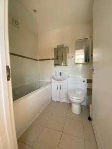 a bathroom with a sink and a toilet and a tub at Lovely Central Romsey Apartment in Romsey