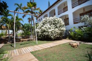 a house with a large flowering bush in front of it at Hotel Kokua Boutique in El Yaque