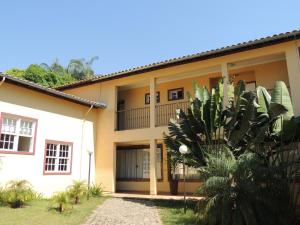 a house with a palm tree in front of it at Pousada Vila Leopoldina in Tiradentes