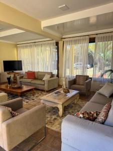 a large living room with couches and a tv at Pousada Vila Leopoldina in Tiradentes
