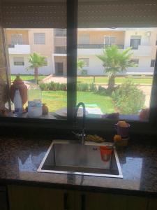 a kitchen sink in a window with a view of a building at Sable d or Mansoria in Aïn Harrouda