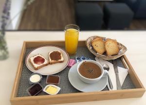 a tray of breakfast food with a cup of coffee and bread at Gota de Piedra in Añelo