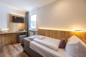 a bedroom with a bed and a window at Hotel Am Martinsberg in Andernach