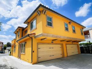a large yellow house with two garage doors at Yellow house Whole 2bedrooms in Alhambra in Alhambra
