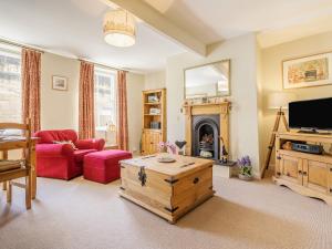 a living room with a red couch and a fireplace at Harry's Den in Alnwick