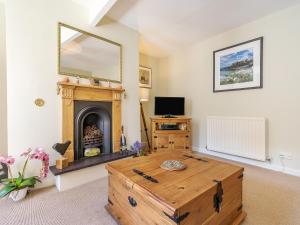 a living room with a wooden coffee table and a fireplace at Harry's Den in Alnwick