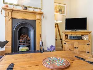 a living room with a fireplace and a table at Harry's Den in Alnwick