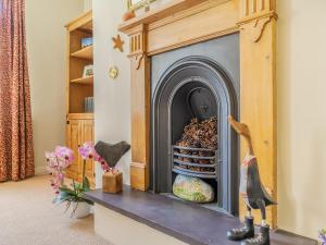 a fireplace in a living room with vases on a table at Harry's Den in Alnwick