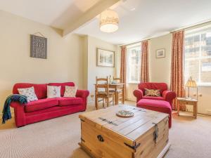 a living room with red couches and a wooden coffee table at Harry's Den in Alnwick +30 photos