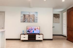 a living room with a tv on a cabinet at Yellow house Whole 2bedrooms in Alhambra in Alhambra