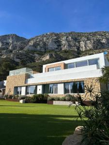 a large house with a mountain in the background at Villa Infinity Denia in Denia
