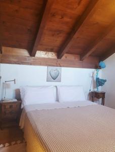 a bedroom with a bed with a wooden ceiling at LA COLLINETTA appartamento di vacanza in Collina d'Oro