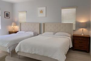 two beds in a white bedroom with two lamps at Yellow house Whole 2bedrooms in Alhambra in Alhambra