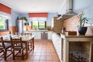 a kitchen with a wooden table and a dining room at Holibai, Feiticeira, Vacaciones familiares, Casa de Ensueño en Galicia in Gondomar