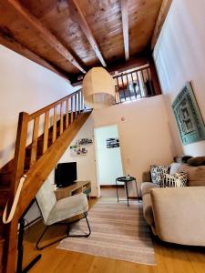a living room with a staircase and a couch at LA COLLINETTA appartamento di vacanza in Collina d'Oro