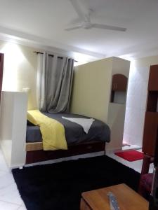 a bedroom with a bed with yellow and black sheets at Wasini gardens,, vingazini in Mtwapa