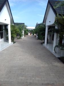 an empty road between two buildings with palm trees at Wasini gardens,, vingazini in Mtwapa +4 photos