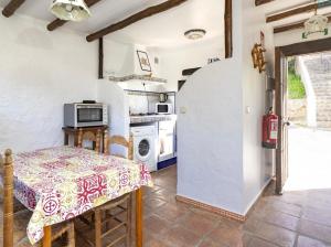 a kitchen with a table and a stove at Casa Rural Albahaca in Jimera de Líbar
