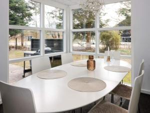 a white dining room with a white table and chairs at Tranquil Waterfront Cottage-By Traum in Hadsund