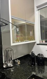 a kitchen with a counter top with a window at Apto Moderno no Centro - Completo e Confortável in Americana +19 photos
