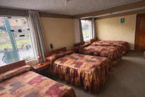 a hotel room with four beds and a window at Hostal Santo Domingo in Cusco