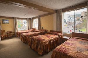 a row of beds in a room with a window at Hostal Santo Domingo in Cusco