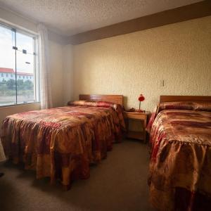 a hotel room with two beds and a window at Hostal Santo Domingo in Cusco