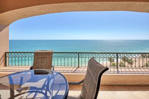 a glass table and chairs on a balcony with the ocean at Penthouse Beachfront at Sonoran Spa in Puerto Peñasco