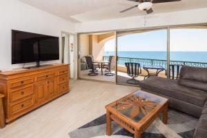 a living room with a couch and a television at Penthouse Beachfront at Sonoran Spa in Puerto Peñasco