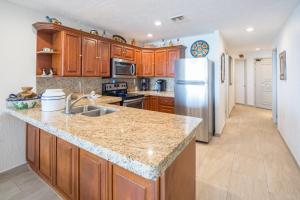 a kitchen with wooden cabinets and a stainless steel refrigerator at Penthouse Beachfront at Sonoran Spa in Puerto Peñasco +28 photos
