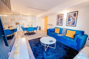 a living room with a blue couch and a table at Modern 2 BR 2 Bath Flat With Balcony & Fast WiFi in Cardiff