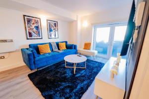 a living room with a blue couch and a blue rug at Modern 2 BR 2 Bath Flat With Balcony & Fast WiFi in Cardiff